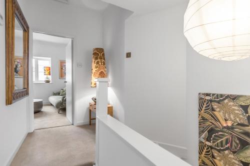 a hallway with white walls and a staircase with a patterned wall at Duke Street brand new central 1 bed flat in Norwich