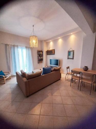 un soggiorno con divano e tavolo di La casa azul a Megalochori (Isola di Agistri)