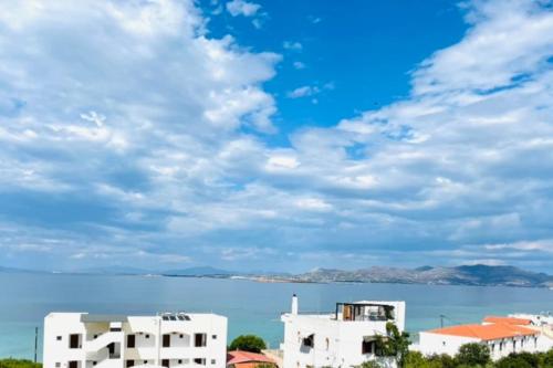 a view of the water and buildings in front of the ocean at La casa azul in Megalochori