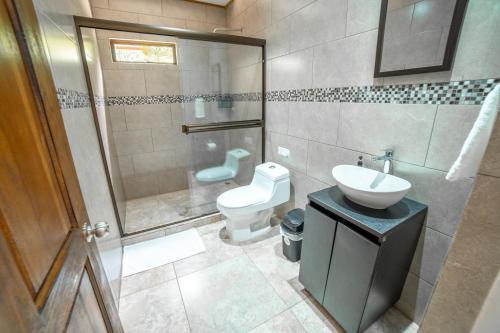 a bathroom with a toilet and a sink and a shower at Natüra Hotel Monteverde in Monteverde Costa Rica