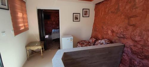 a living room with a couch and a red wall at Asem Studio apartment in Wadi Musa