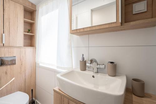 a bathroom with a sink and a toilet at Ostseecamp Lübecker Bucht Ferienhaus "Min Tohuus" in Scharbeutz