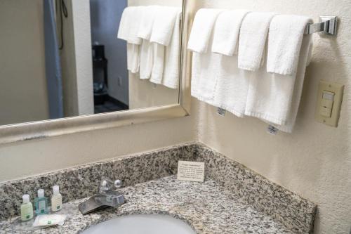 a bathroom with a sink and a mirror and towels at Quality Inn Seymour I-65 in Seymour
