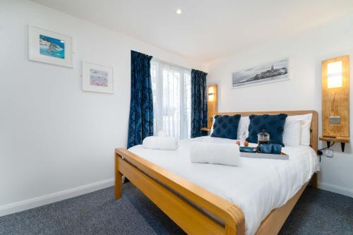 a bedroom with a large bed with two laptops on it at Little Waves in St Ives