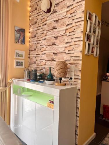a kitchen with a white counter and a stone wall at Casa Rehman in Ratzeburg