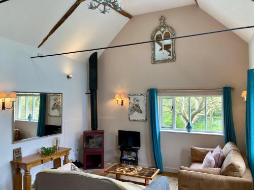 a living room with a couch and a window at Simpers Drift, Great Glemham in Saxmundham