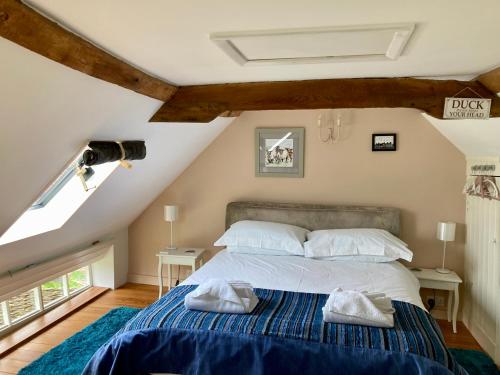 a bedroom with a bed with two towels on it at Simpers Drift in Saxmundham