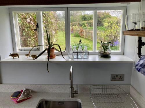 a kitchen counter with a window above a sink at Simpers Drift in Saxmundham