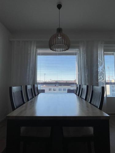 einen Esstisch mit Stühlen und ein großes Fenster in der Unterkunft Arctic Deluxe Residence in Rovaniemi