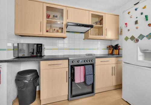 a kitchen with a stove and a microwave at Valley Rise By My Getaways Free Parking in Portslade