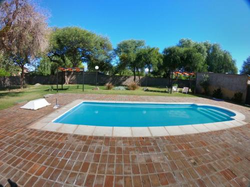 a swimming pool in a yard with a brick patio at Las Catalinas cabañas in San Fernando del Valle de Catamarca