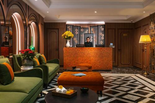 a hotel lobby with a man standing at the cash register at Hanoi L'Heritage Hotel & Gym - Spa in Hanoi