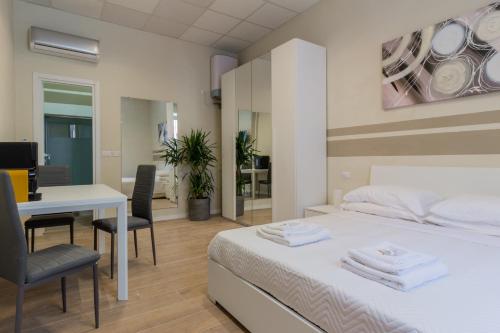 a bedroom with a bed and a table and chairs at Center Rooms in Piacenza