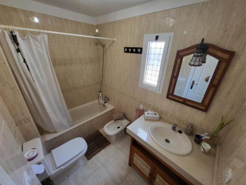 a bathroom with a sink and a toilet and a mirror at Apartment next to Ajabo Beach Pool & Ocean view in Callao Salvaje