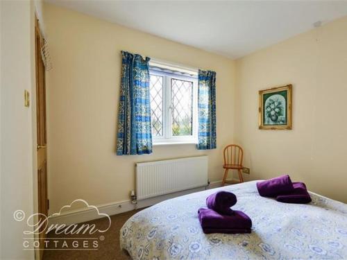 een slaapkamer met een groot bed met paarse kussens erop bij Frome Lodge House in Dorchester
