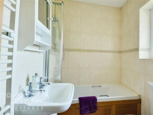 a white bathroom with a sink and a shower at Frome Lodge House in Dorchester