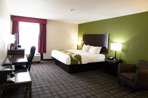 a hotel room with a bed and a chair at Quality Inn Seymour I-65 in Seymour