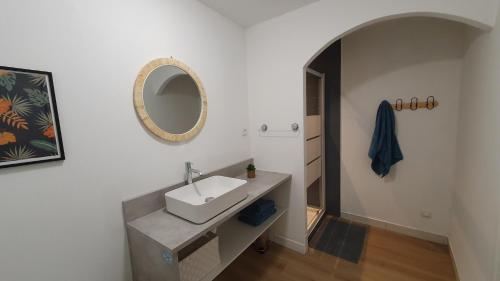 La salle de bains est pourvue d'un lavabo et d'un miroir mural. dans l'établissement Le Central, à Lagnieu
