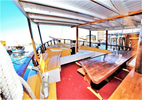 a boat with a table and benches on the deck at Rhythm Floating Hostel - Zadar in Zadar