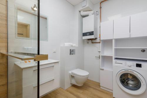 uma casa de banho branca com uma máquina de lavar roupa e uma máquina de lavar roupa. em Pet friendly Apartment Górna 31 by Renters em Ustronie Morskie