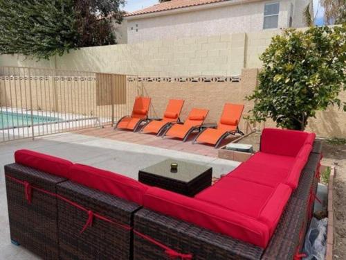 a large red couch sitting next to a pool at Work, Life, Luxury! Luxe Vegas Home w Firepit+Pool in Las Vegas