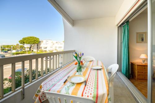 un balcon avec une table et des chaises sur un balcon dans l'établissement Appartement donnant sur le port de plaisance de Port Camargue et a proximité des plages, au Grau-du-Roi