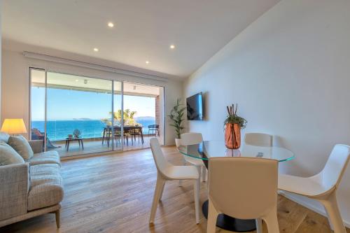 a living room with a table and a view of the ocean at The Fetch - Residenze Esclusive sull'Acqua in Alghero
