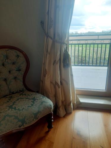 una silla sentada en una habitación con ventana en Killossy Lodge, en Naas