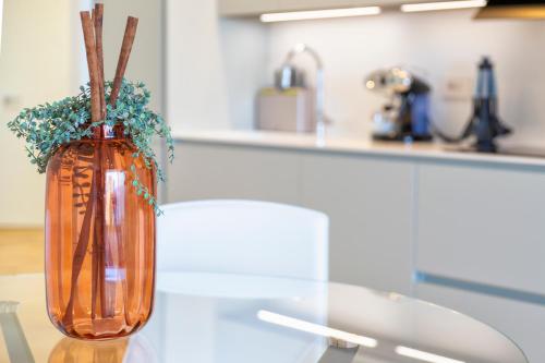 a vase with flowers in it sitting on a table at The Fetch - Residenze Esclusive sull'Acqua in Alghero