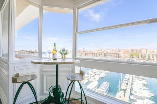 une pièce avec une table et deux tabourets devant une fenêtre dans l'établissement Vieux-Port - Vue exceptionnelle - 3 ch et clim, à Marseille