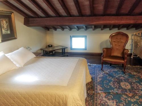a bedroom with a bed and a chair at B&B Il Casolare Di Bonci in Santa Maria a Monte