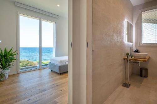 a bedroom with a bed and a view of the ocean at The Fetch - Residenze Esclusive sull'Acqua in Alghero