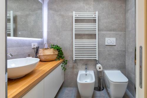 a bathroom with a sink and a toilet at The Fetch - Residenze Esclusive sull'Acqua in Alghero