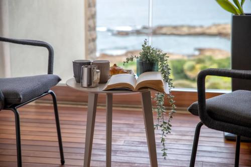 a table with an open book and two chairs at The Fetch - Residenze Esclusive sull'Acqua in Alghero