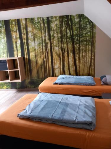 two beds in a room with a mural of trees at Ter Ename n°1 in Ename