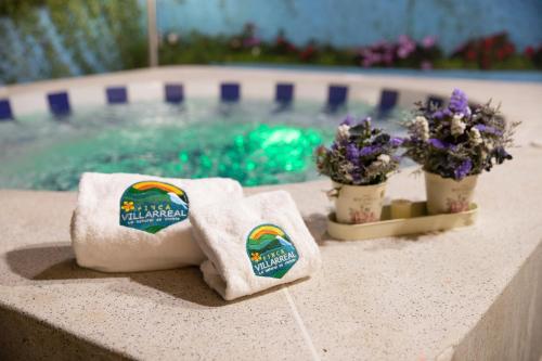 two towels and flowers next to a swimming pool at Finca Villarreal in Cali