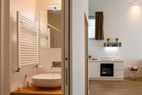 W łazience znajduje się biała umywalka i lustro. w obiekcie Relais Palazzo Olimpia - Corso Vittorio Emanuele w mieście Salerno