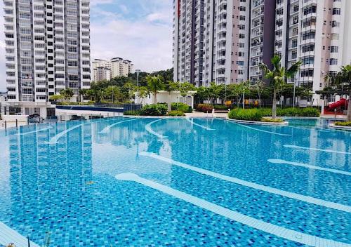 a large blue swimming pool in front of tall buildings at Putrajaya 3R2B 10pax Acond Coway WiFi HyppTV Pool Gym Kitchen in Putrajaya