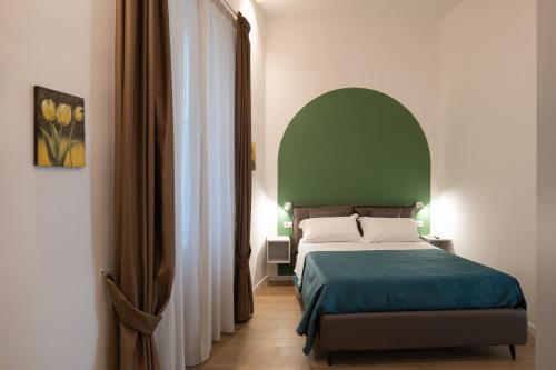 sypialnia z łóżkiem z zielonym zagłówkiem w obiekcie Relais Palazzo Olimpia - Corso Vittorio Emanuele w mieście Salerno