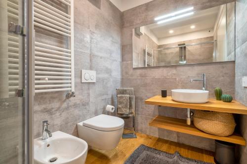 a bathroom with a toilet and a sink and a mirror at The Fetch - Residenze Esclusive sull'Acqua in Alghero