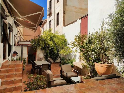 eine Außenterrasse mit Tisch, Stühlen und Pflanzen in der Unterkunft Dar Ar Nur Albaycin con patio in Granada