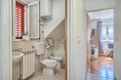 y baño con aseo y lavamanos. en Couple's Getaway in the Center of Hvar w/Sea View, en Hvar