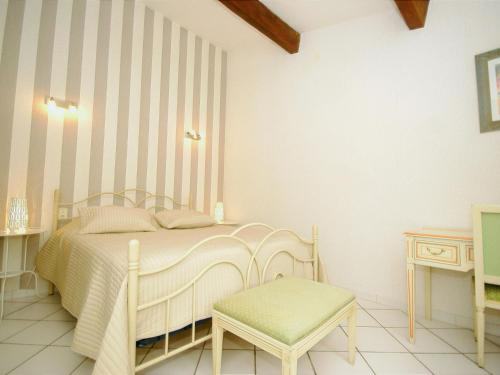une chambre avec un lit blanc et une chaise dans l'établissement Holiday Home in Le Thor with Private Pool, au Thor