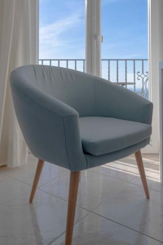 a blue couch sitting in a room with a balcony at Albergo La Prora in Capri