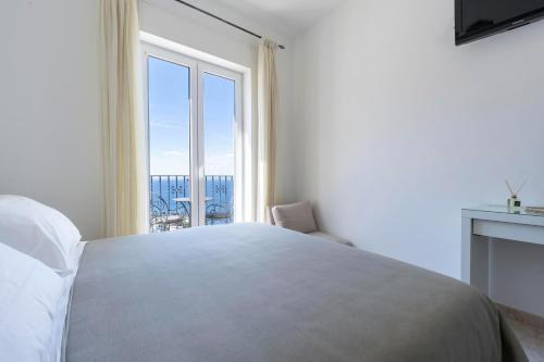 a bedroom with a large bed and a large window at Albergo La Prora in Capri
