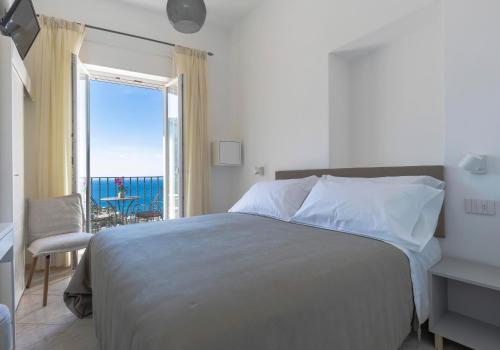 a bedroom with a bed and a view of the ocean at Albergo La Prora in Capri