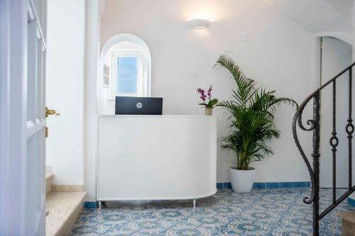 a white desk with a laptop on it in a hallway at Albergo La Prora in Capri