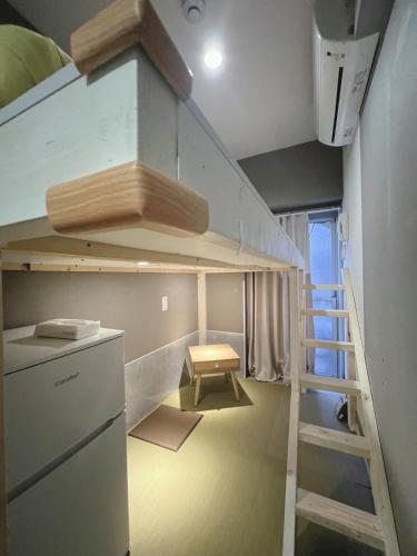 a small room with a bunk bed and a ladder at 誠家　MAKOTO HOSTEL in Tokyo