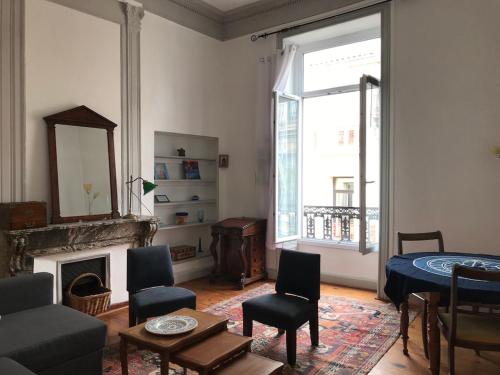 ein Wohnzimmer mit einem Kamin, einem Tisch und Stühlen in der Unterkunft Centre ville -cadre royal - appartement de charme. in Sète