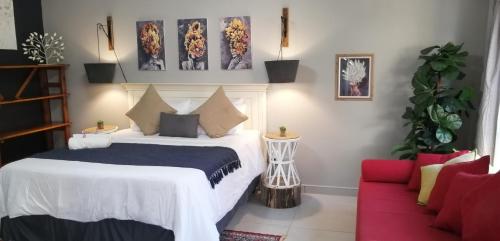 a bedroom with a white bed and a couch at The Hancock Inn in Klerksdorp